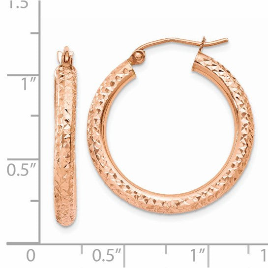 14k Rose gold hoop earrings with textured design on a white background with measurement scale.